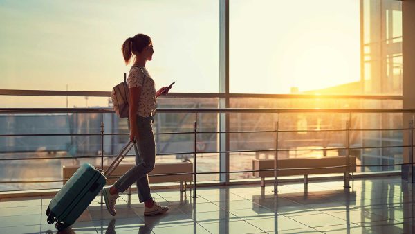 Tourist at the airport reading travel recommendations to Peru on his cell phone