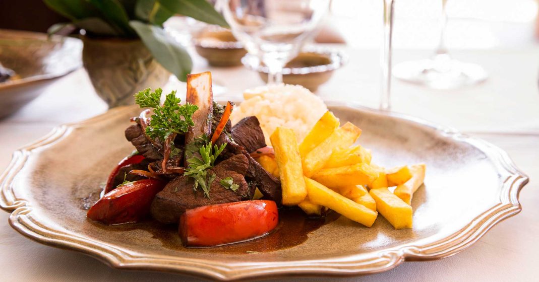 Peruvian gourmet food, lomo saltado with beef, French fries, tomato and onion