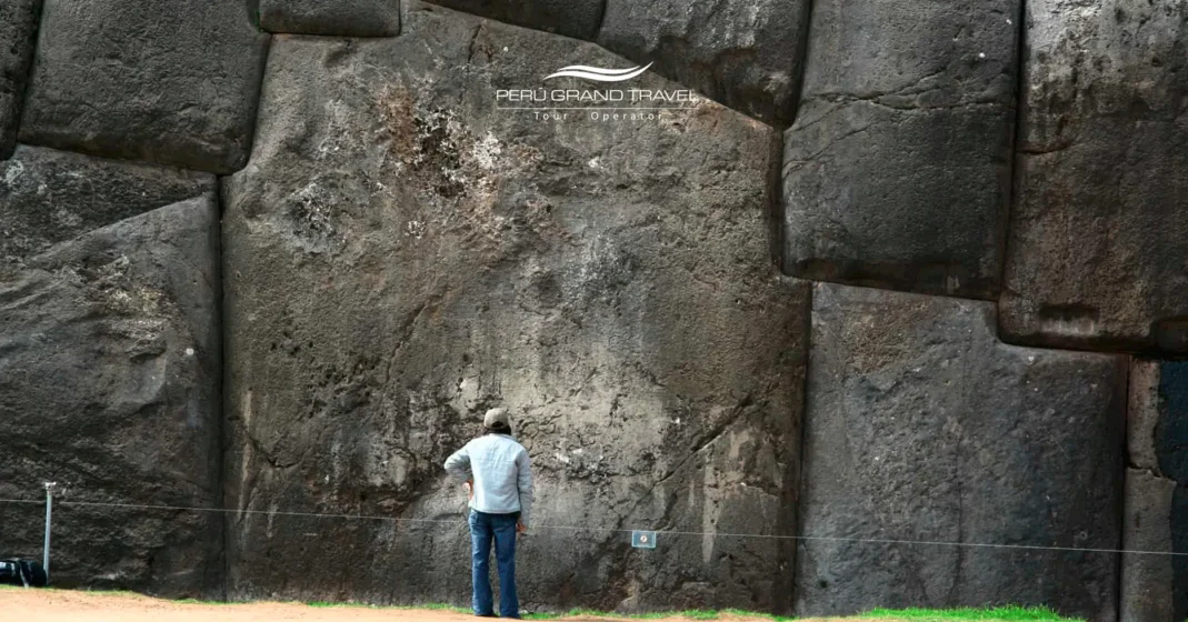 Tourist standing next to massive stone walls of Sacsayhuaman, Peru