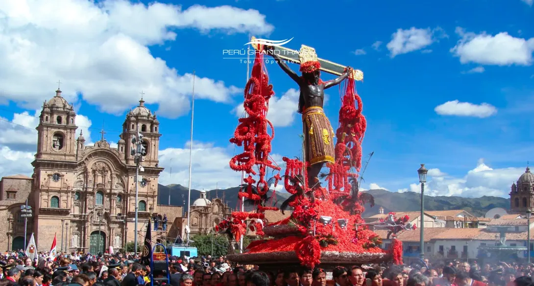 Lord of the Earthquakes procession in Cusco’s Plaza de Armas, featuring the crucified Christ adorned with red ñucchu flowers and thousands of faithful gathered during Holy Monday.